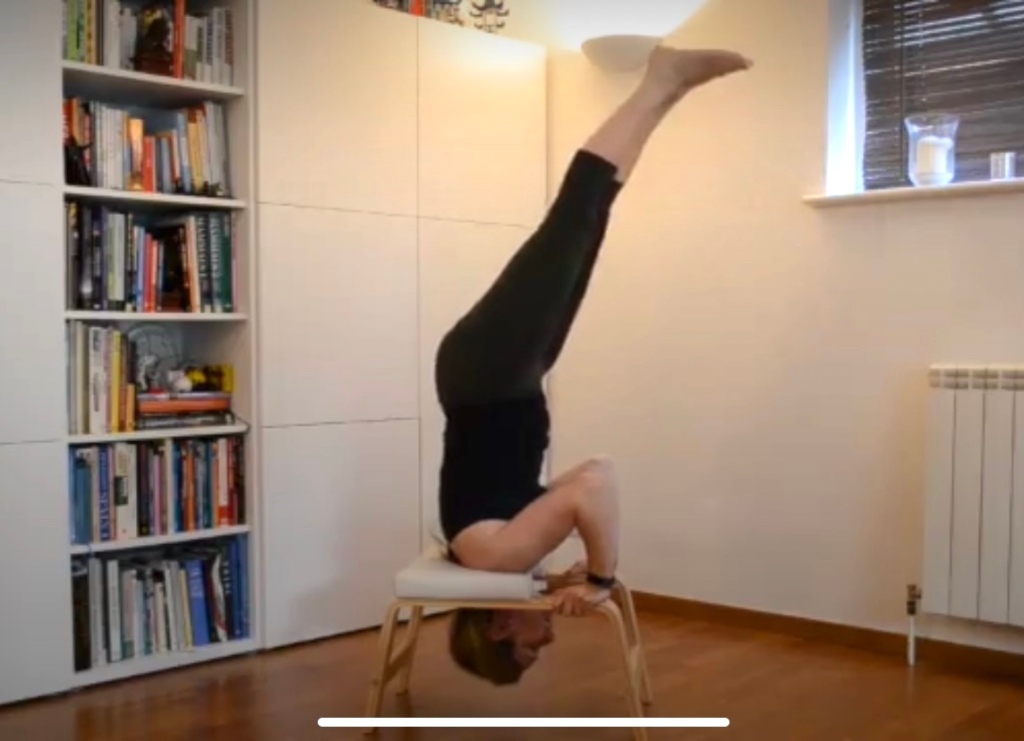 Woman practising inversion using feet up trainer prop